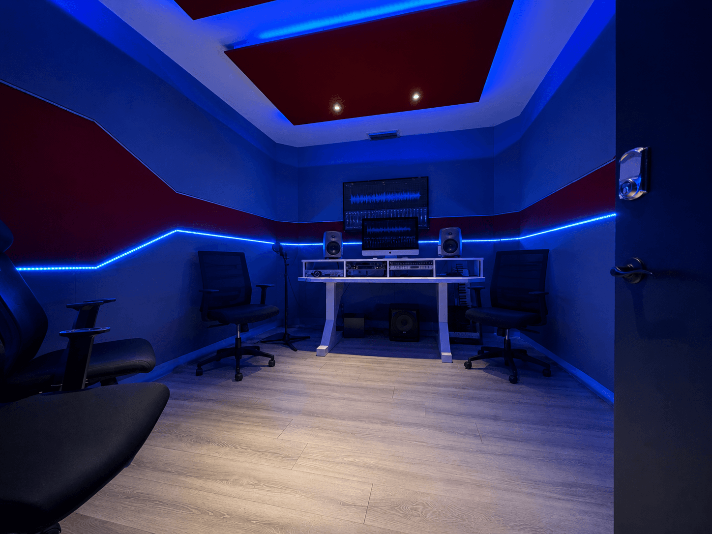 C Room with blue lighting, production workstation, and studio monitors